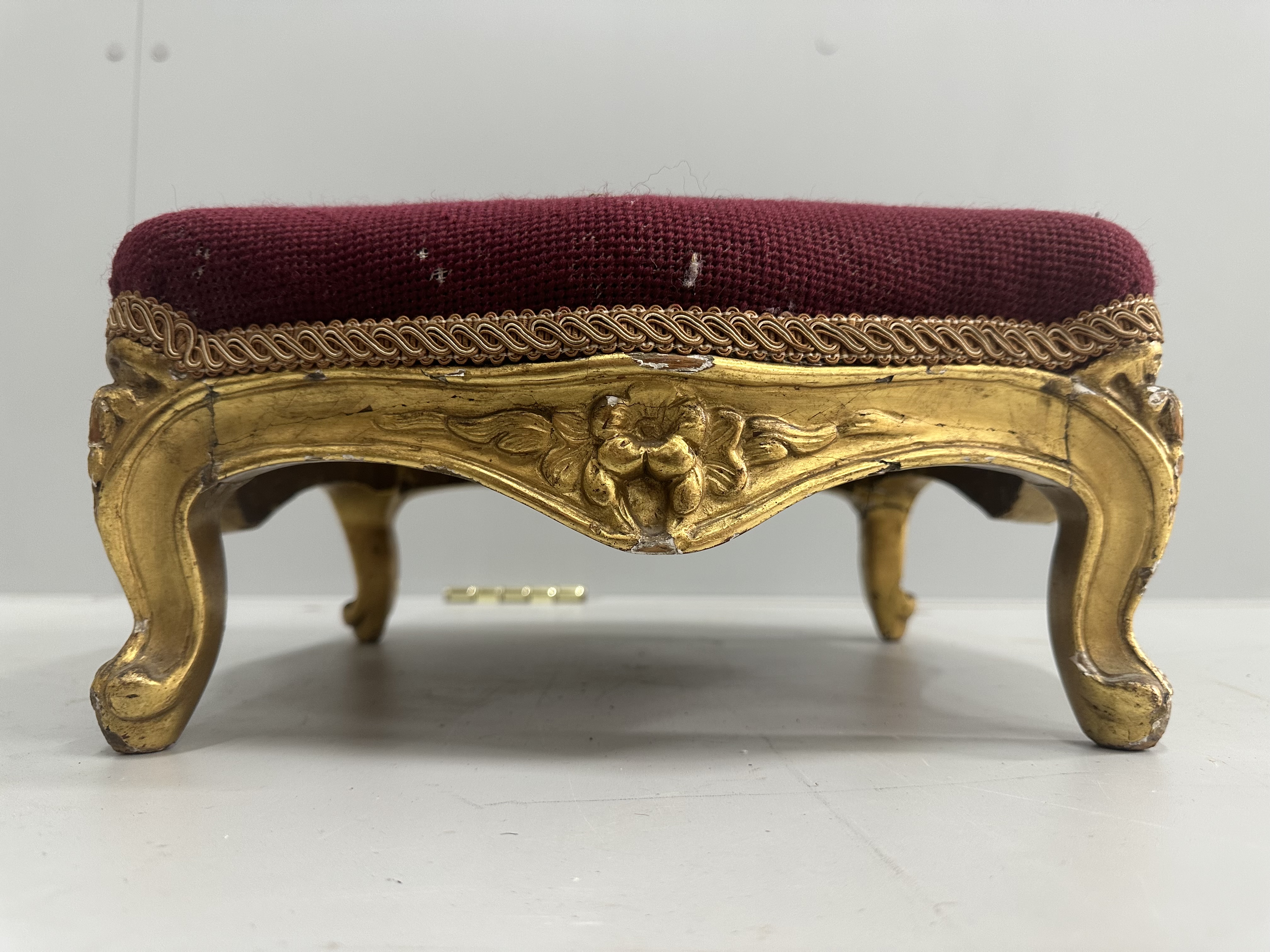 A Victorian carved giltwood footstool, width 36cm, height 16cm